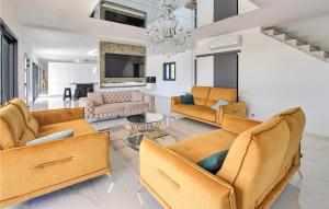 ein Wohnzimmer mit Sofas und einem Kronleuchter in der Unterkunft Amazing Home In Pont Saint Esprit in Pont-Saint-Esprit