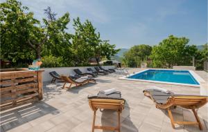 a pool with a bunch of chairs and a swimming pool at Cozy Home In Vrgorac With Outdoor Swimming Pool in Vrgorac