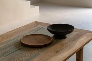 a black bowl sitting on top of a wooden table at Scorpios Beach in Monolithos