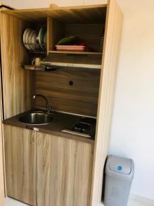 a kitchen with a sink in a wooden cabinet at Studios Litsa in Pefkari