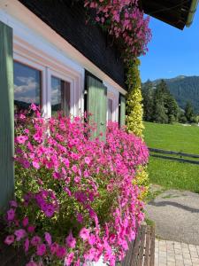 een bos van roze bloemen voor een huis bij Gästehaus Nussbaumer in Balderschwang