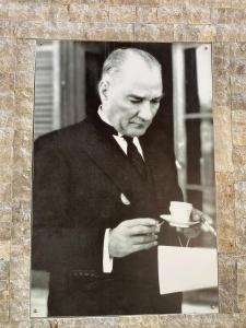 una vieja foto de un hombre sosteniendo una taza de café en Tuna BUTİK OTEL, en Bodrum City