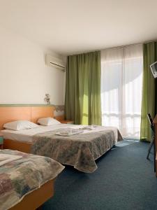 a hotel room with two beds and a window at Mint Family Hotel in Ravda