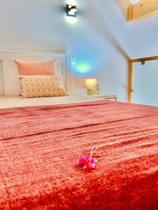 a pink flower on the bed in a bedroom at Quinta das Carpas in Tavira