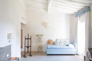 Agriturismo Fattoria Di Maiano في فيسولي: غرفة معيشة مع أريكة زرقاء في غرفة