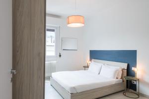 a bedroom with a white bed and a blue wall at RELSTAY - Gae Aulenti - 1BR in Milan