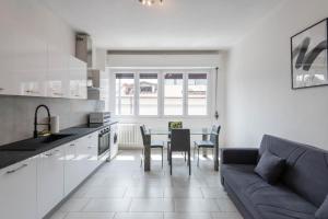 a kitchen and living room with a couch and a table at RELSTAY - Gae Aulenti - 1BR in Milan