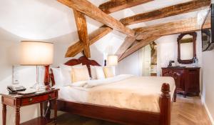 a bedroom with a large bed with wooden beams at The Dominican in Prague