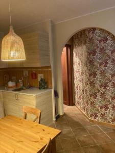 a kitchen with a dining table and a wall at Grazioso appartamento tra Roma e il mare in Rome