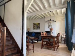 a dining room and living room with a table and chairs at Villa Fontaine avec piscine intérieur chauffée-Maison de campagne Familiale -idéal Vacances ou Séjour Professionnel -3 chambres-Bureau séparé -Lit Bébé - Parking Facile & Gratuit in Fontaine-la-Gaillarde
