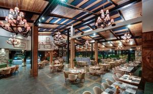 un restaurante con mesas, sillas y lámparas de araña en Grand Hotel Therme en Banya