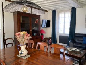 ein Wohnzimmer mit einem Tisch und einer Vase darauf in der Unterkunft Villa Fontaine avec piscine intérieur chauffée in Fontaine-la-Gaillarde