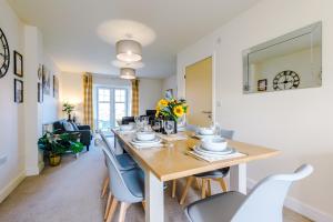een eetkamer en een woonkamer met een tafel en stoelen bij Spacious 4-Bed Townhouse in Crewe by 53 Degrees Property, Ideal for Contractors & Business, FREE Parking - Sleeps 8 in Crewe