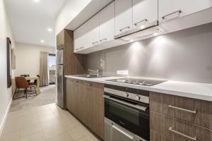 a kitchen with a stove top oven and a sink at Quest Nowra in Nowra