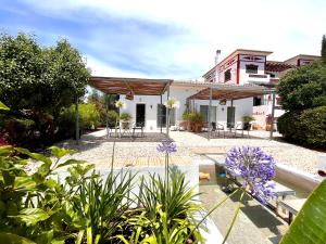 a house with a courtyard with purple flowers at Quinta das Carpas in Tavira