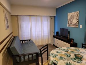 1 dormitorio con 1 cama, TV y mesa en Guadalupe depto 2 amb con cochera macrocentro en Mar del Plata