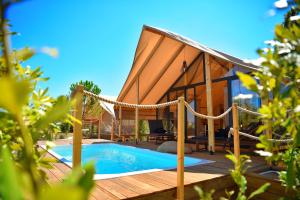 una casa con piscina su una terrazza in legno di Floria Glamping Garden a Labin