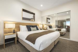 a hotel room with a large bed and a large window at Quest Nowra in Nowra