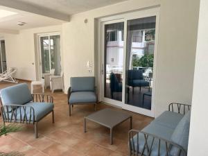 un soggiorno con sedie e un tavolo di Le Cale Camera Privata in Residence a Favignana