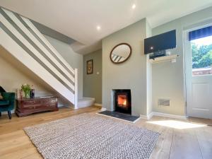a living room with a fireplace and a staircase at The Granary in Rowde