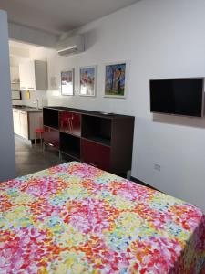 a bedroom with a bed with a colorful blanket at Arco Bianco - Monolocali in Tortolì