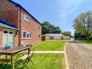 a brick house with a table and chairs in the yard at The Granary in Rowde