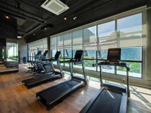 um ginásio com uma fila de passadeiras e janelas em Hotspring 2 Room Premium 1510 Suite Sunway Onsen Theme Park View, 5pax em Ipoh