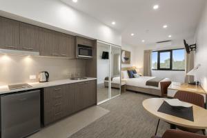 a living room with a kitchen and a bedroom at Quest Nowra in Nowra