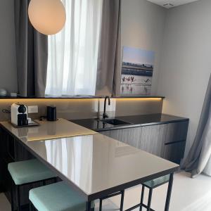 a kitchen with a counter with two chairs and a table at Donna Caterina in Monopoli