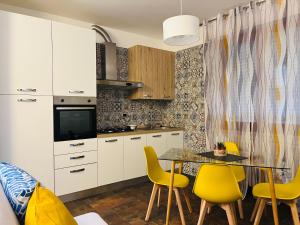 a kitchen with a dining table and yellow chairs at Giramondo in Senigallia