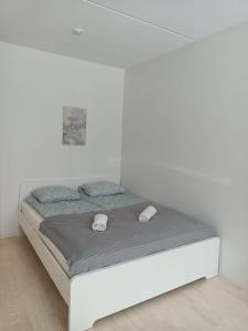 Łóżko w białym pokoju z białą ścianą w obiekcie Transit Apartment HEL Airport w mieście Vantaa