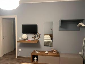 a room with a bed and a television on a wall at Le Cale Camera Privata in Residence in Favignana