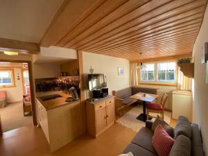 a living room with a couch and a kitchen in a house at Gästehaus Nussbaumer in Balderschwang