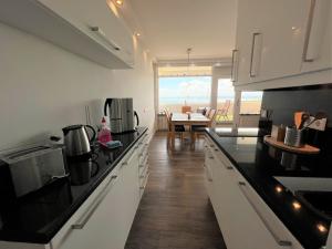 a kitchen with black counter tops and a dining room at Panoramic App B10-7 in Sierksdorf