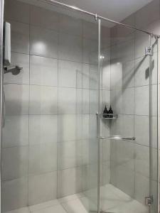 a shower with a glass door in a bathroom at Modern Dpulze Soho fit 4pax,Netflix provided in Cyberjaya