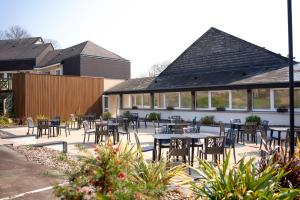 a patio with tables and chairs in a building at ibis Styles Fougeres in Beaucé
