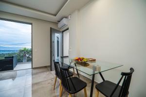 a dining room with a glass table and chairs at Jarko Luxury Houses in Argoulidhés
