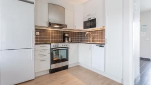 a kitchen with white cabinets and a stove at Lägenheter Hamrafjället Tänndalen in Tänndalen