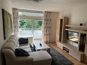 a living room with a couch and a large window at Wald-Idyll: Urlaub im Grünen in Bad Harzburg