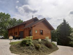 a small wooden house with a sign in front of it at Gîte du Chalet - Le studio en pleine nature 