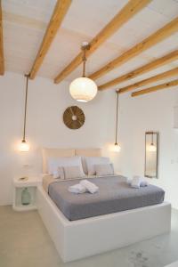 una camera bianca con un grande letto in una stanza di Orion Milos a Pollonia