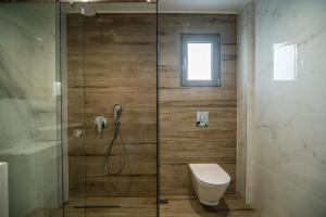 a bathroom with a glass shower with a toilet at Jarko Luxury Houses in Argoulidhés