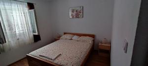 a small bedroom with a bed and a window at Apartment Biondic in Senj