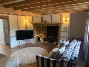 a living room with a couch and a fireplace at Cosy luxury 3 bed cottage in The Surrey Hills in Ockley