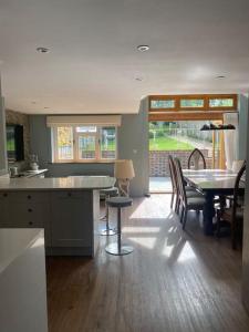 a kitchen and dining room with a table and chairs at Cosy luxury 3 bed cottage in The Surrey Hills in Ockley