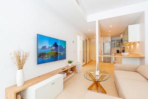 uma sala de estar com um sofá e uma televisão na parede em CALA ALTA sunny apartment em Benidorm