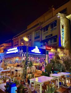 a group of tables in front of a building at night at Larimar Hotel Cesme in Çeşme