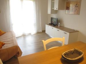 ein Wohnzimmer mit einem Tisch und einem Sofa in der Unterkunft Appartamento Vigna del Mar in Lido