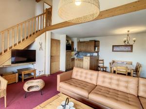 a living room with a couch and a staircase at Appartement Duplex 8 pers avec Balcon, Piscine, Sauna, Hammam et Parking Privé - Fontcouverte-la-Toussuire - FR-1-417-164 in La Toussuire