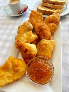 a plate of fried food on a table with a cup of coffee at Anxhelos Hotel in Himare